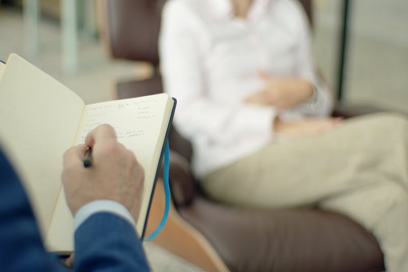 Psicólogo en su consulta de PsicoSalud Almería escuchando atentamente a un paciente en un espacio seguro
